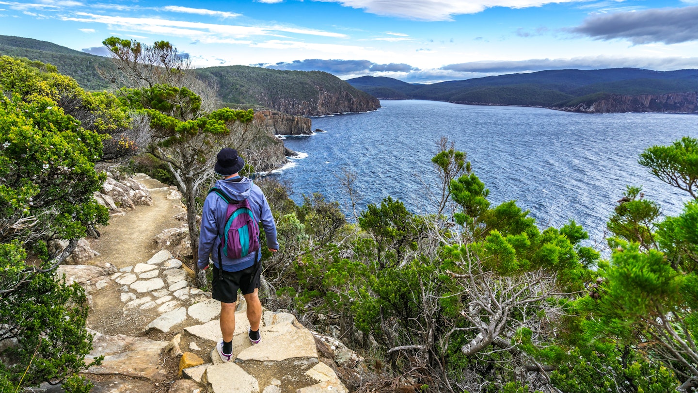 Man hiking toward Fortescue Bay along the coast.