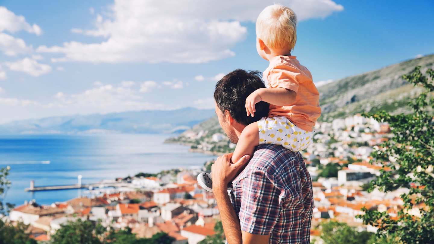 Father and son look at a view over the Croatian coast near Split