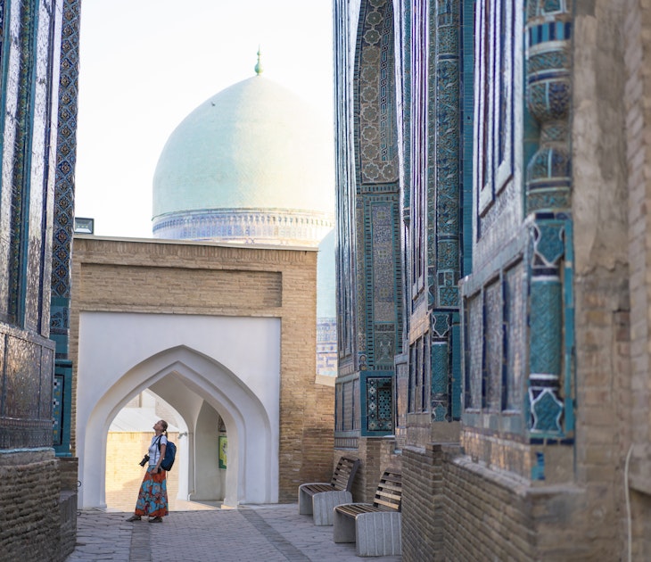 Senior woman on the path between memorial buildings of Shakhi Zinda Mausoleum which is memorial complex of Islamic architecture from 9 to 12. century in Samarkand, Uzbekistan
1129859652
ancient, architecture, art, asia, building exterior, craft, cultures, decoration, east, entrance, facade, famous place, history, indigenous culture, monument, multi colored, old, pattern, photography, religion, sky, spirituality, travel destinations, unesco world heritage site, mausoleum, silk road, tomb, samarkand, tribal art, central asia, mosaic, ceramics, cemetery, memorial, uzbekistan, tile, turquoise colored, persian culture, photography themes, footpath, single lane road, horizontal, women, one woman only, senior adult, shah-i-zinda
A woman looking up at the memorial buildings of Shah-I-Zinda Mausoleums in Samarkand, Uzbekistan