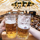 09 August 2024, Bavaria, Straubing: Visitors to the Gäubodenvolksfest toast with beer mugs in a marquee. With around 1.3 million guests, Gäubodenvolksfest is the second largest folk festival in Bavaria after Munich's Oktoberfest. It lasts until August 19th.