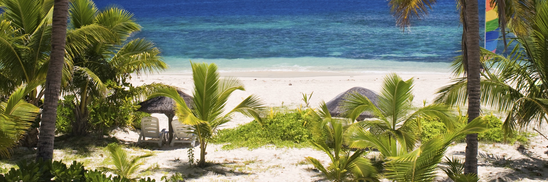 Sail boat seen through palm trees, Mamanuca Group islands, Fiji