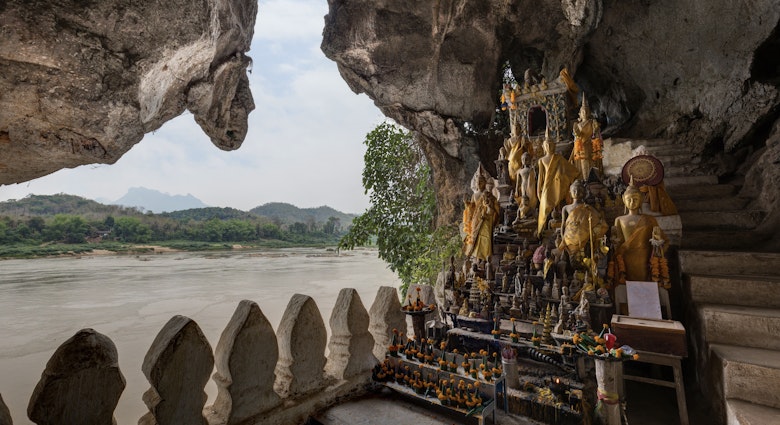 View of the Mekong River and many golden and wooden Buddha statues and religious offerings inside the Tham Ting Cave at the famous Pak Ou Caves near Luang Prabang in Laos.
956152240
View of the Mekong River and many golden and wooden Buddha statues and religious offerings inside the Tham Ting Cave at the famous Pak Ou Caves near Luang Prabang in Laos.