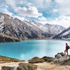 Man with backpack looking at picturesque landscape of emerald lake and snowy mountains in Almaty, Kazakhstan
961506872
clouds, destinations, getaway, lifestyle, male, millennial, mountain ranges, mountains, observing, recreation, scenic, vacation, view, young man
Full length of backpacker looking at view while standing by lake against mountains and cloudy sky during winter - stock photo