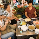 Diners at Gia Ngu market, Old Quarter.
25410-41
ARCHIVE, Asia, Hanoi, Vietnam, bowl, cap, clothing, commerce, compatible, culture, day, eat, female, furniture, glass, hat, headwear, luxury, market, outdoors, people, sit, spoon, table, togetherness, tourism, tourist, travel, urban, woman, women, South-East Asia, adults only, casual clothing, chinese ethnicity, city life, food & drink, food and drink industry, group of people, healthy lifestyle, high angle view, local landmark, mature adult, mature woman, mature women, medium group of people, mid adult, mid adult woman, mid adult women, old quarter, one woman, only women, part of, place of interest, side view, table setting, three quarter length, urban living, urban scene, weekend activities, young adult, young woman, young women, Adult, Cafeteria, Child, Cup, Female, Food, Girl, Handbag, Hat, Indoors, Lunch, Male, Man, Meal, People, Person, Restaurant, Teen, Woman
Asia, Hanoi, South-East Asia, Vietnam, adults only, bowl, cap, casual clothing, chinese ethnicity, city life, clothing, commerce, compatible, culture, day, eat, female, food & drink, food and drink industry, furniture, glass, group of people, hat, headwear, healthy lifestyle, high angle view, local landmark, luxury, market, mature adult, mature woman, mature women, medium group of people, mid adult, mid adult woman, mid adult women, old quarter, one woman, only women, outdoors, part of, people, place of interest, side view, sit, spoon, table, table setting, three quarter length, togetherness, tourism, tourist, travel, urban, urban living, urban scene, weekend activities, woman, women, young adult, young woman, young women
Diners at Gia Ngu market, Old Quarter.