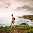 Woman hiking a deserted beach at sunset in Huatulco, Oaxaca State. Mexico.