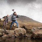 Couple crossing river, Fairy Pools, near Glenbrittle, Isle of Skye, Hebrides, Scotland