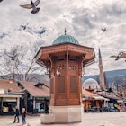 15 March 2024, Sarajevo, Bosnia and Herzegovina: Sarajevo's lively Sebilj fountain square offers a glimpse into the city's bustling market scene and Islamic architecture.; Shutterstock ID 2460648201; purchase_order: 65050; job: Lonely Planet Online Editorial; client: First-time guide to Sarajevo; other: Brian Healy
2460648201
ancient, architecture, attraction, balkan, bascarsija, bosnia, building, cafe, capital, center, central, city, cityscape, crowd, culture, europe, exterior, famous, fountain, herzegovina, historical, islamic, landmark, market, monument, mosque, old, ottoman, pigeons, religion, sarajevo, sebilj, sightseeing, square, street, structure, symbol, tour, tourism, tourists, town, traditional, travel, turkish, urban, view, visit, wooden
Sarajevo, Bosnia and Herzegovina: Sarajevo's lively Sebilj fountain square offers a glimpse into the city's bustling market scene and Islamic architecture
