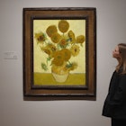 LONDON, ENGLAND - MARCH 25: A woman looks at Vincent van Gogh's Sunflowers painting at the EY Exhibition: Van Gogh and Britain press day which opens at Tate Britain on March 25, 2019 in London, United Kingdom. (Photo by Stuart C. Wilson/Getty Images)